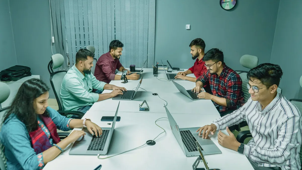 Gruppo di professionisti che lavora con laptop in uno spazio condiviso
